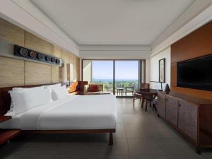 a bedroom with a large bed and a flat screen tv at Pullman Oceanview Sanya Bay Resort & Spa in Sanya +212 photos