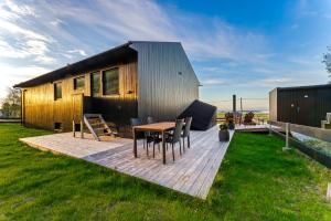a house with a wooden deck with a table and chairs at Villa Walter Lofoten with SAUNA in Kvalnes