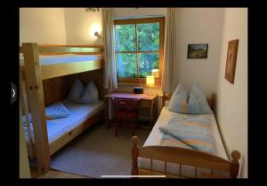 ein Schlafzimmer mit zwei Etagenbetten und einem Schreibtisch in der Unterkunft Grüne Au in St. Wolfgang