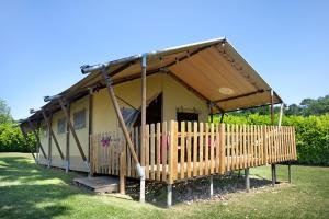 a small yellow house with a wooden fence at Lodge Les Étoiles in Saint-Sauveur