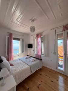a bedroom with a bed and two windows at Villa Rosa in Plomari