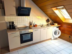 a kitchen with a stove and a washing machine at Ferienwohnung Mika in Bad Rothenfelde