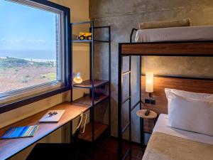 a bedroom with a bed and a desk with a window at ibis Sao Luis in São Luís +118 photos