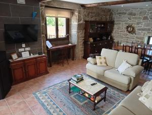 a living room with a couch and a table at Casa da Eira in Lobios