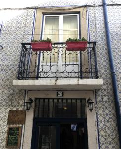 a building with a balcony with two plants on it at Casa de Cima in Lisbon