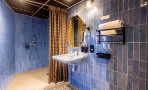 a blue tiled bathroom with a sink and a shower at Hôtel BOHEM, Sacré-Cœur in Paris