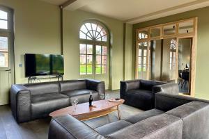 a living room with two leather couches and a table at Maison proche Baie de Somme & Le Tréport-Terrasse in Biencourt +40 photos