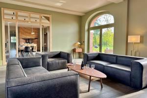 a living room with two couches and a table at Maison proche Baie de Somme & Le Tréport-Terrasse in Biencourt