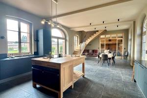 a large kitchen with a table and a dining room at Maison proche Baie de Somme & Le Tréport-Terrasse in Biencourt
