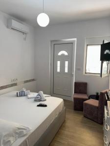 a bedroom with a bed and a chair and a door at Adela's Saranda Central Apartment in Sarandë