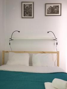 a bed with white pillows and two pictures on the wall at Casa de Cima in Lisbon
