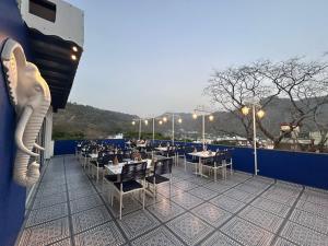 a restaurant with tables and chairs on a balcony at Hotel Ivory Hills in Kotdwāra