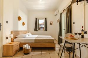 a bedroom with a bed and a table with wine glasses at Amorosa Nest - Adults Only by Eutopia in Syvota +29 photos