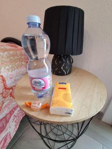a bottle of water on a table next to a lamp at Stella Marys Nord in Olbia