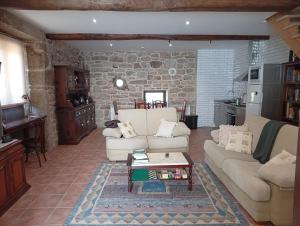 a living room with a couch and a table at Casa da Eira in Lobios +11 photos