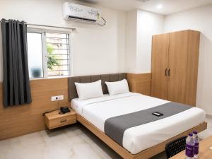 a bedroom with a large bed and a window at Hotel Narsingi in Gundipet