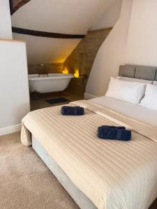 a bedroom with a bed with two blue pillows on it at Luxury Holt Duplex with Bath Suite in Holt