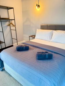 two blue pillows are sitting on a bed at Luxury Holt Duplex with Bath Suite in Holt +14 photos