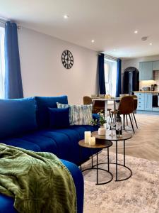 a living room with a blue couch and a table at Luxury Holt Duplex with Bath Suite in Holt