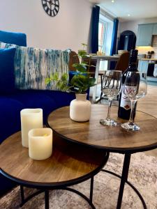 a living room with two tables and a bottle of wine at Luxury Holt Duplex with Bath Suite in Holt