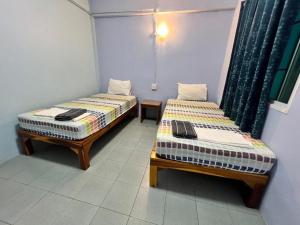 two beds sitting next to each other in a room at J Home Aonang in Ban Nong Chaeng