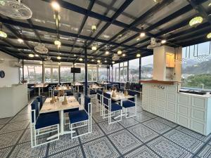 a dining room with tables and chairs and windows at Hotel Ivory Hills in Kotdwāra