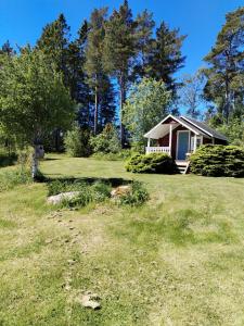 a small house in the middle of a yard at The little cottage in Saltvik +4 photos