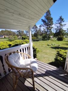 a rocking chair on a porch with a view of a yard at The little cottage in Saltvik