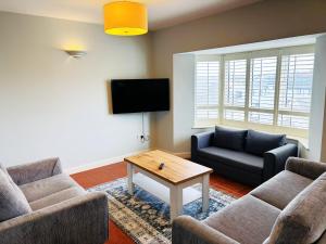 a living room with two couches and a tv at Atlantic Hotel in Lahinch