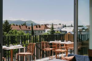 a balcony with tables and chairs and a view of a city at Der Stasta - New Opening in Vienna