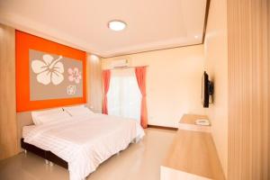 a bedroom with a bed and an orange wall at Naphet Resort in Phetchaburi +10 photos