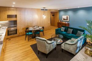 - un salon avec un canapé bleu et une table dans l'établissement Abbey Apartments City Center, à Porto