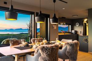 a dining room with a table and chairs with a view at Villa Walter Lofoten with SAUNA in Kvalnes +27 photos