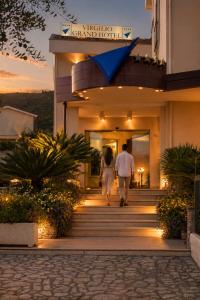 a man and woman walking down the stairs of a building at Virgilio Grand Hotel in Sperlonga