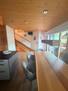 a living room with a large wooden table and chairs at Willi's Holidays Home in Saalbach-Hinterglemm +17 photos