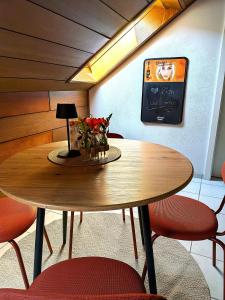a wooden table with chairs and a table with flowers on it at Ferienwohnung Mika in Bad Rothenfelde