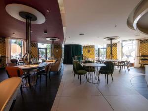a restaurant with tables and chairs and windows at Pullman Brussels Centre Midi in Brussels