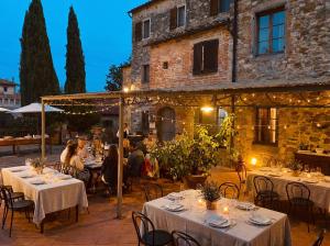a group of people sitting at tables in front of a building at Tenuta Lupinari in Bucine