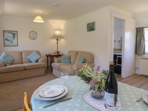 a living room with a table with a bottle of wine at Walk Farm Cottage in Gloucester