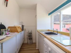 a kitchen with white cabinets and a sink and a window at Walk Farm Cottage in Gloucester +20 photos