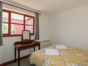 a bedroom with a bed and a mirror and a desk at Walk Close in Gloucester