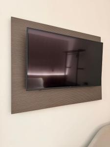 a flat screen tv hanging on a wall at Le Cantine Rooms & Luxury Space in San Mango Piemonte