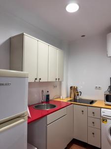 a kitchen with a sink and a red counter top at Casa Carmen II in Montoro