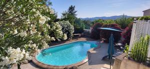 a swimming pool in a garden with flowers at Les parfums du midi in Saint-Victor-de-Malcap