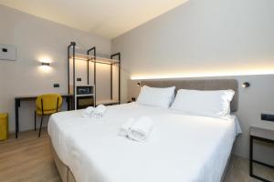 ein Schlafzimmer mit einem großen weißen Bett und einem Schreibtisch in der Unterkunft Best Western Hotel Garda in Affi