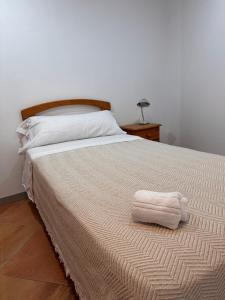 a bedroom with a bed with two towels on it at Casa Carmen II in Montoro