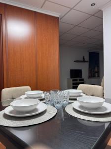 a table with plates and glasses on top of it at Casa Carmen II in Montoro