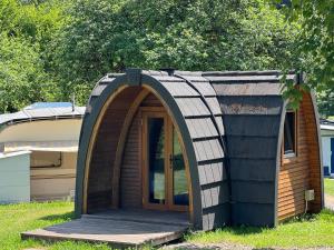 a small house with a wooden door in the grass at Camping Wies-Neu in Dillingen +12 photos