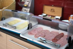 a tray of meat and sausage on a counter at Szieszta Panzió in Sárvár