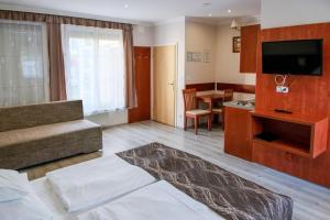 a hotel room with a bed and a dining room at Szieszta Panzió in Sárvár